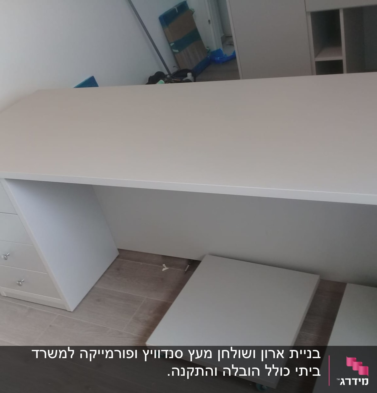 שולחן עבודה עם מגירות ולוח עץ על הרצפה